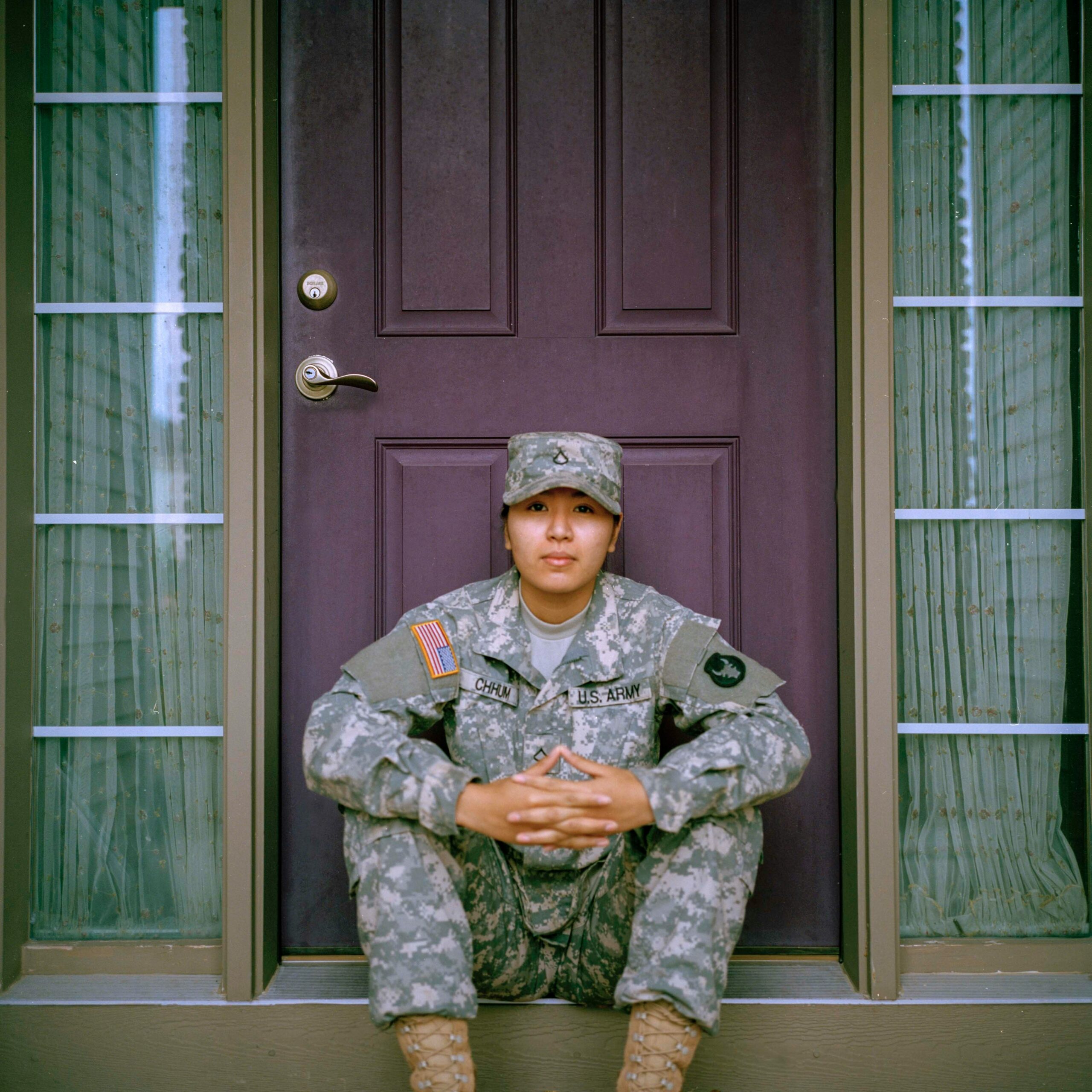 female us reservist sitting in front of house door