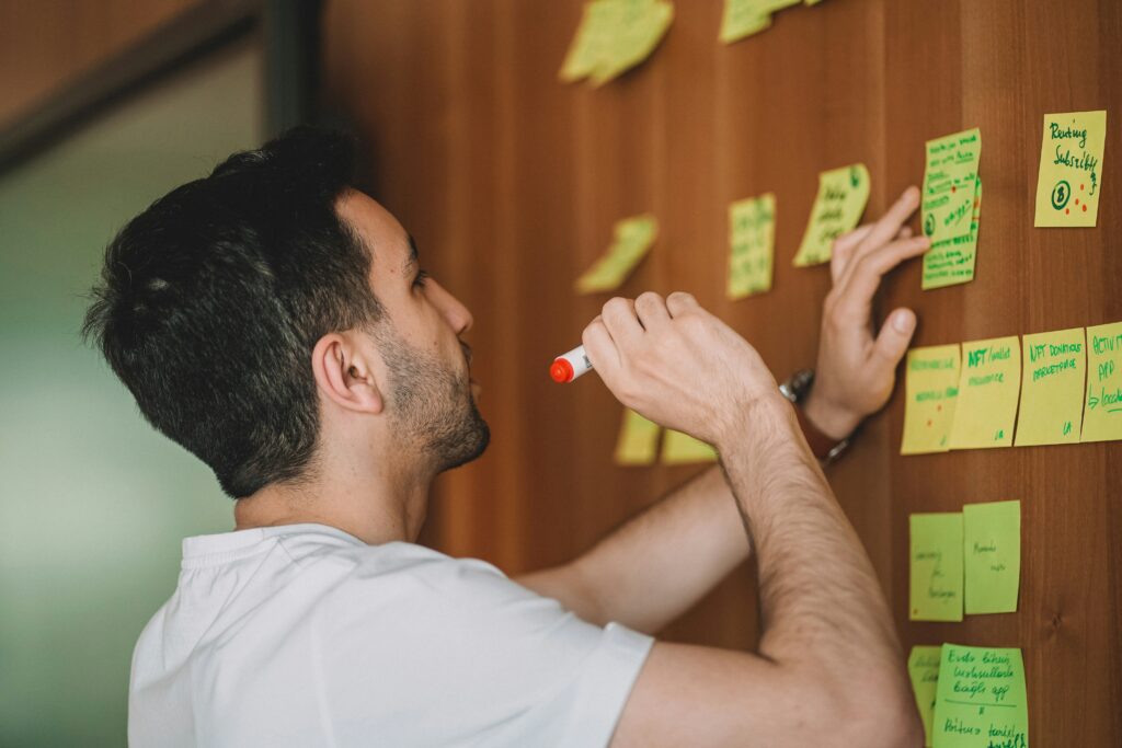 Man brainstorming with post-its for blog article 25. I am starting a business, how does this affect my German taxes?